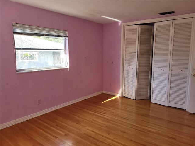 unfurnished bedroom featuring light hardwood / wood-style floors and a closet