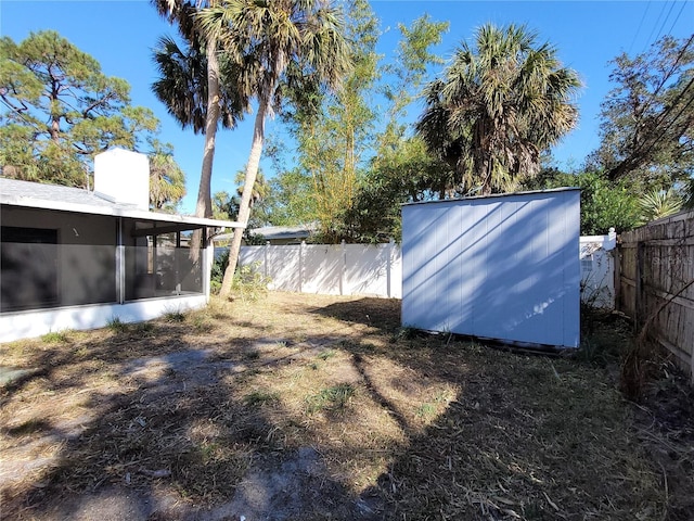 view of yard featuring a storage shed and a sunroom