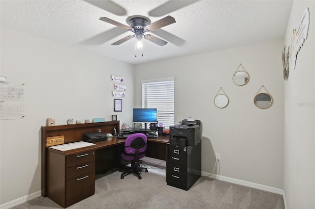 office space with a textured ceiling, light colored carpet, and ceiling fan