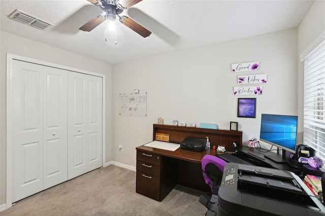 carpeted office space with a textured ceiling and ceiling fan