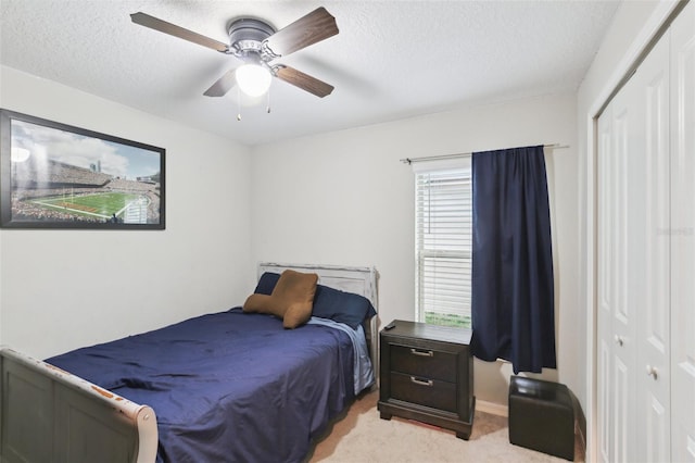 bedroom featuring a closet, ceiling fan, light colored carpet, and multiple windows