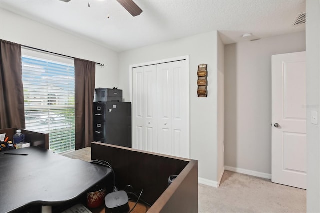 carpeted office with ceiling fan and a textured ceiling