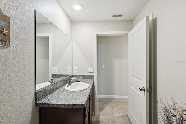 bathroom with a textured ceiling and vanity