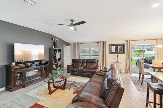 living room featuring ceiling fan, a healthy amount of sunlight, light tile patterned floors, and lofted ceiling