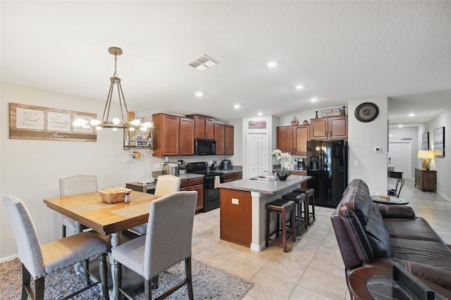 dining area with sink, a chandelier, light tile patterned floors, and a textured ceiling