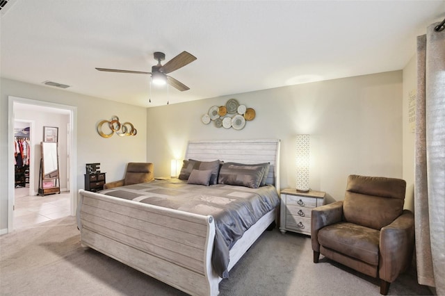 bedroom featuring a closet, ceiling fan, a spacious closet, and light carpet