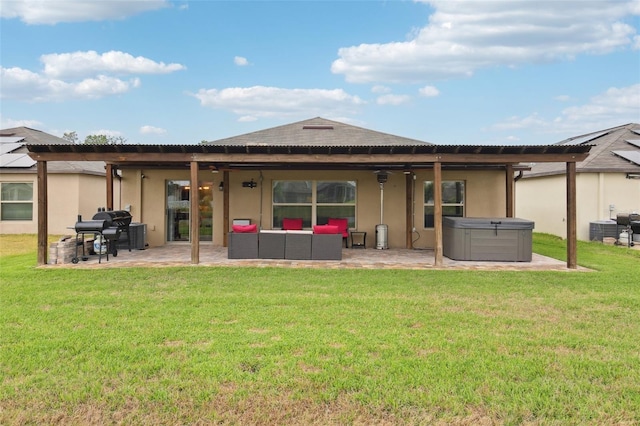 back of house featuring a lawn, a patio, a hot tub, and outdoor lounge area