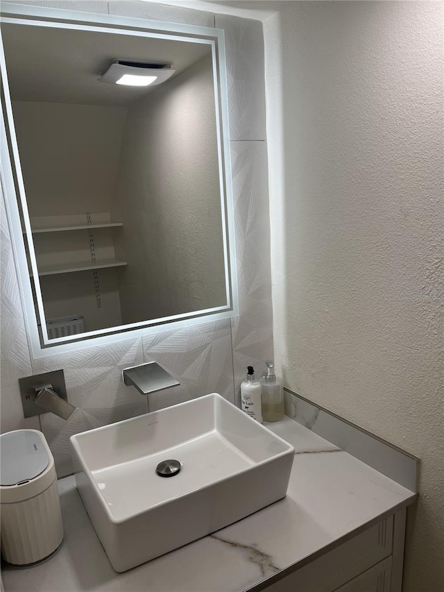 bathroom with a textured wall and a sink