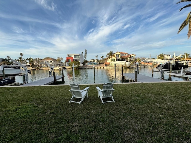 view of dock with a yard and a water view