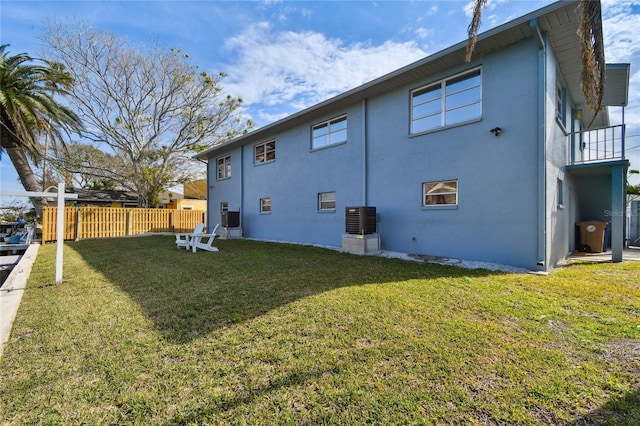 rear view of property with cooling unit and a yard