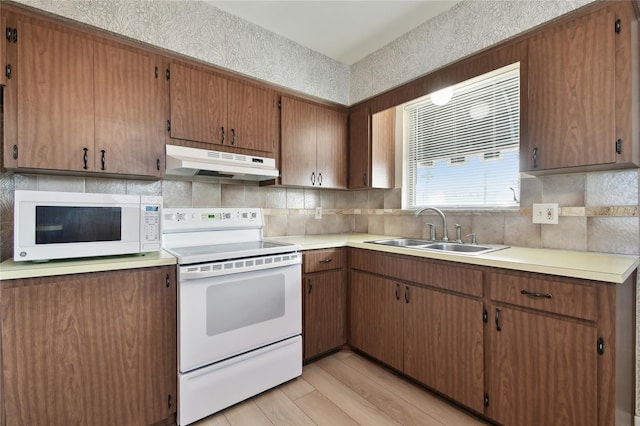 kitchen featuring light hardwood / wood-style floors, sink, and white appliances