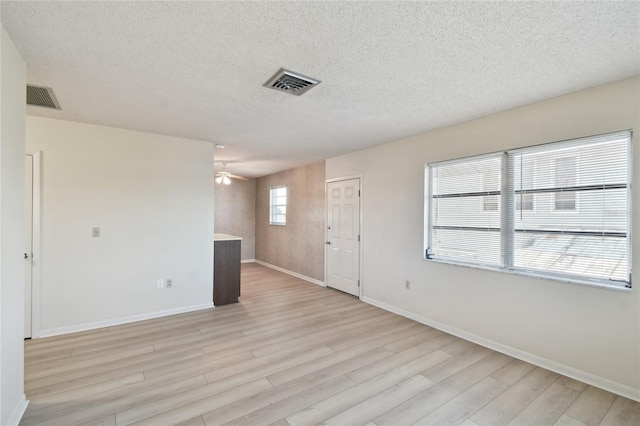 unfurnished room featuring light hardwood / wood-style floors, a textured ceiling, and ceiling fan