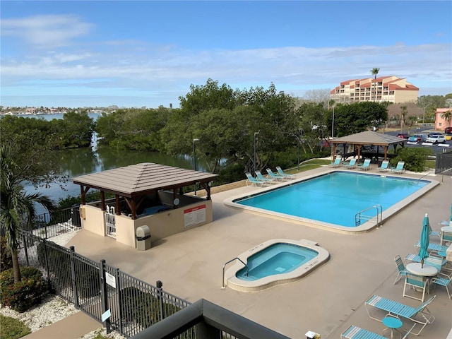 view of pool with a patio, a water view, a gazebo, and a community hot tub