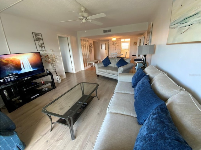 living room with light wood-type flooring and ceiling fan