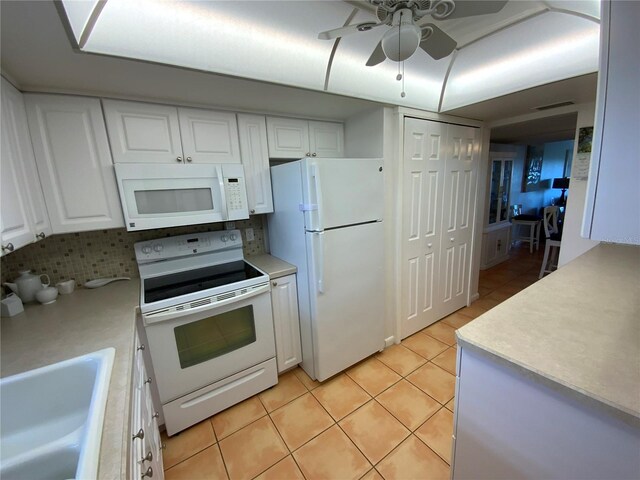 kitchen with white appliances, white cabinetry, decorative backsplash, and light tile patterned floors