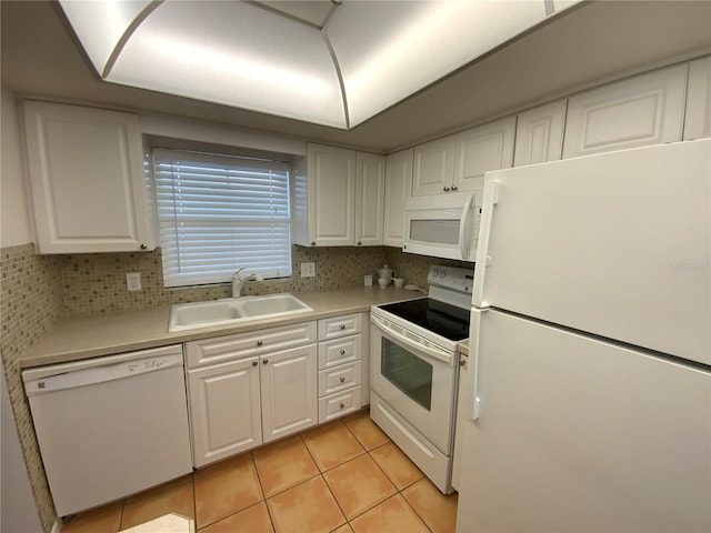 kitchen with light tile patterned floors, sink, white appliances, and white cabinets