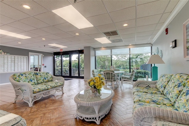 living room featuring crown molding, light parquet floors, a mail area, and expansive windows