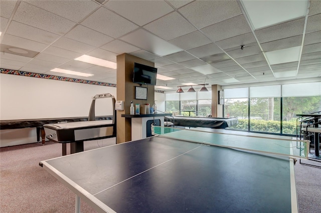 recreation room featuring a drop ceiling and carpet