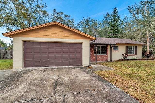 single story home featuring a garage and a front yard