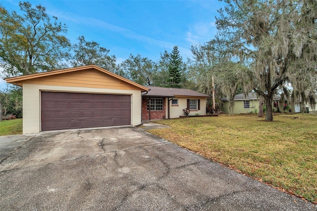 ranch-style home featuring a garage and a front lawn