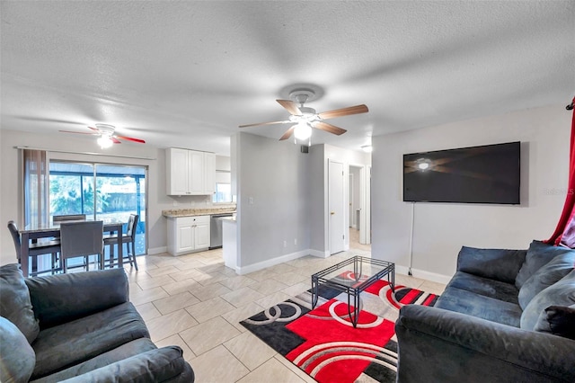 living room featuring ceiling fan, light tile patterned floors, and a textured ceiling