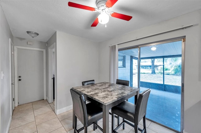 dining area featuring light tile patterned flooring, ceiling fan, and a textured ceiling