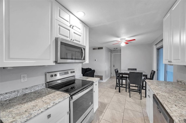 kitchen with white cabinetry, light tile patterned flooring, ceiling fan, and appliances with stainless steel finishes