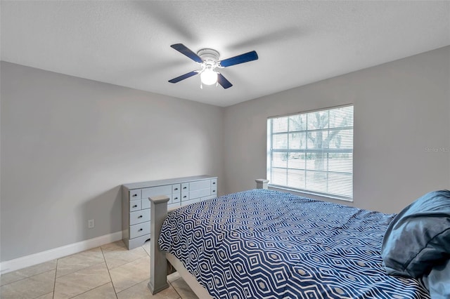 bedroom with light tile patterned floors, a textured ceiling, and ceiling fan