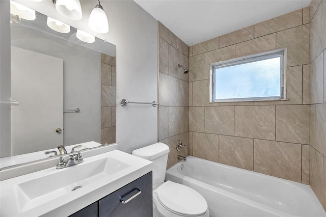 full bathroom with tiled shower / bath, vanity, and toilet