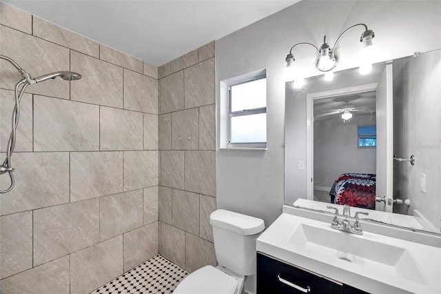 bathroom with vanity, a tile shower, and toilet