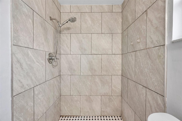 bathroom with toilet and tiled shower