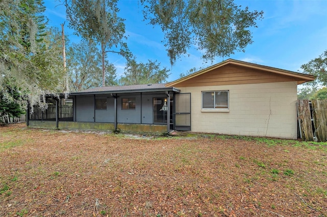 rear view of house featuring a sunroom