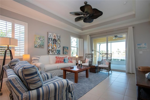 living room featuring plenty of natural light, a tray ceiling, and light tile patterned floors