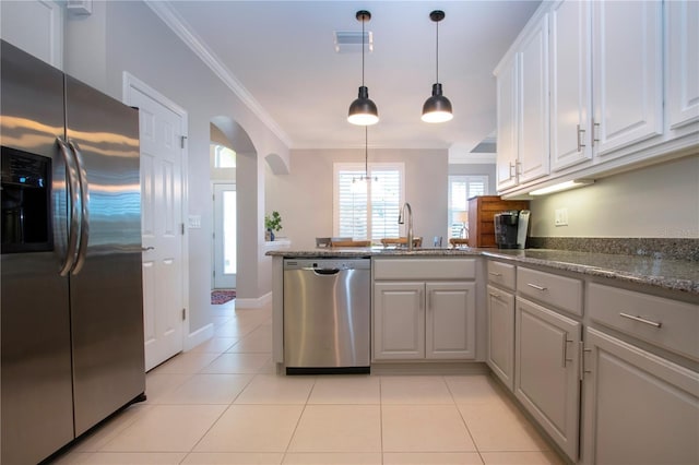 kitchen with sink, white cabinets, light tile patterned floors, stainless steel appliances, and crown molding