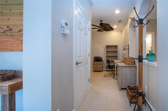 hall with crown molding and light tile patterned floors