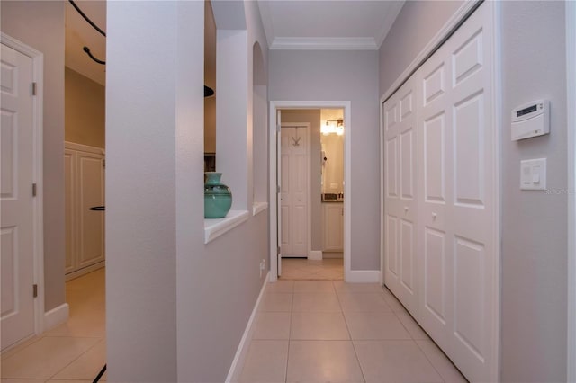 hallway with light tile patterned floors and ornamental molding