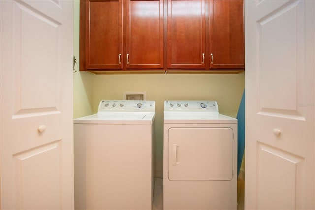 washroom featuring cabinets and washer and clothes dryer