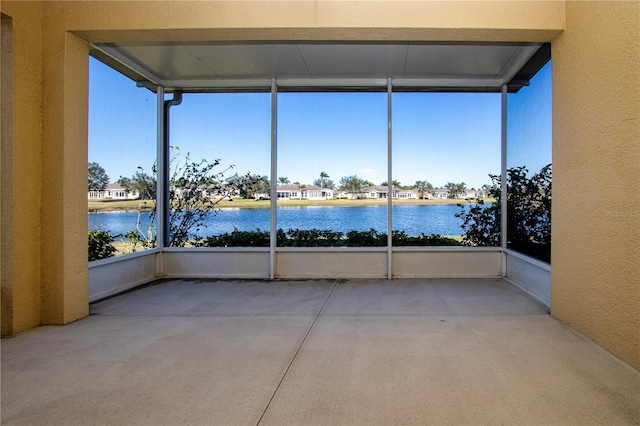 unfurnished sunroom featuring a water view