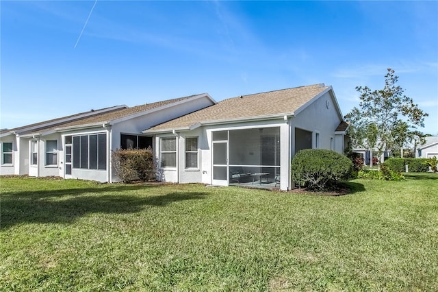 back of property with a sunroom and a lawn