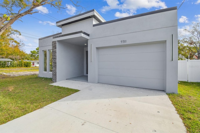 contemporary house featuring a front yard and a garage