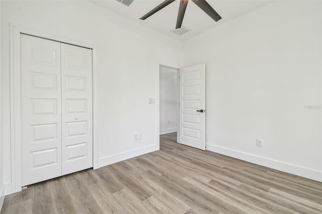 unfurnished bedroom featuring light wood-type flooring, ceiling fan, and a closet