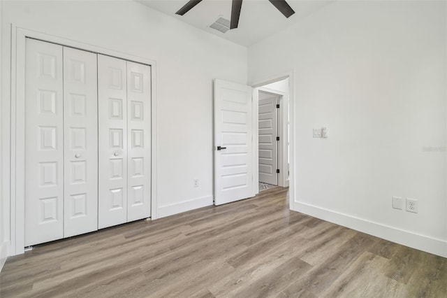 unfurnished bedroom with ceiling fan, a closet, and light hardwood / wood-style flooring