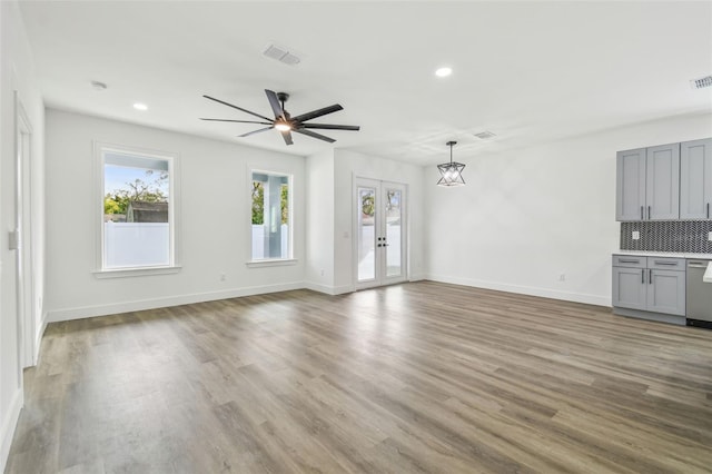 unfurnished living room featuring ceiling fan, hardwood / wood-style floors, and french doors