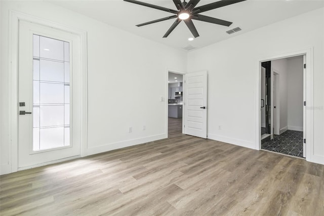 unfurnished bedroom featuring ceiling fan, ensuite bathroom, and light hardwood / wood-style flooring