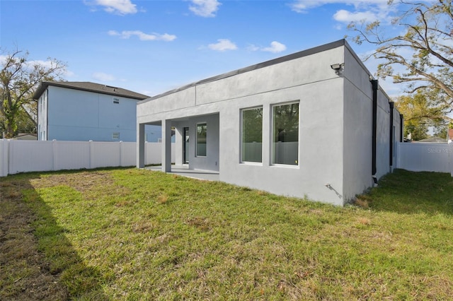 rear view of property featuring a patio area and a yard