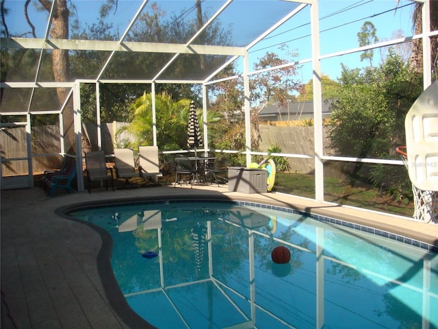 view of swimming pool featuring glass enclosure