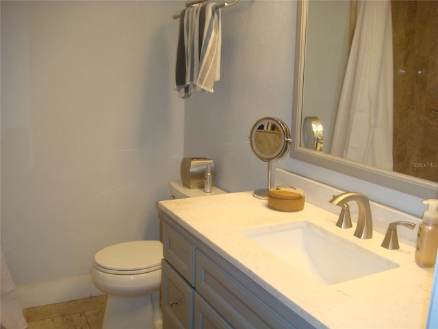 bathroom with tile patterned flooring, vanity, and toilet