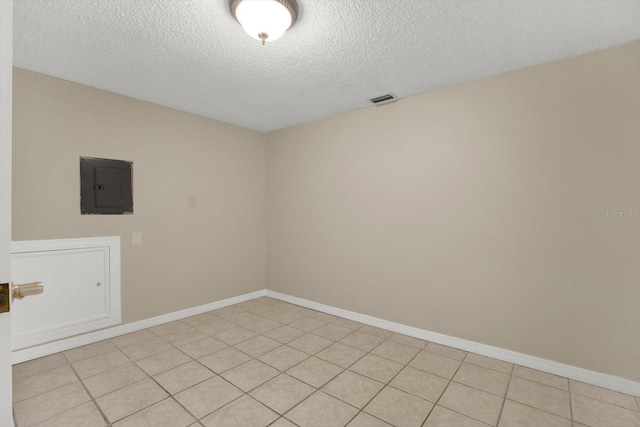 spare room with electric panel and a textured ceiling