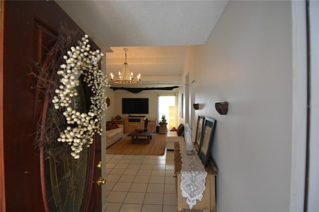 corridor featuring light tile patterned flooring and an inviting chandelier