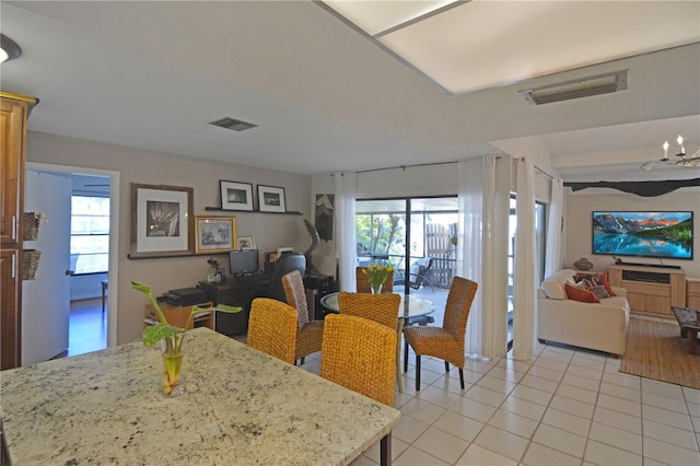 tiled dining room featuring a chandelier